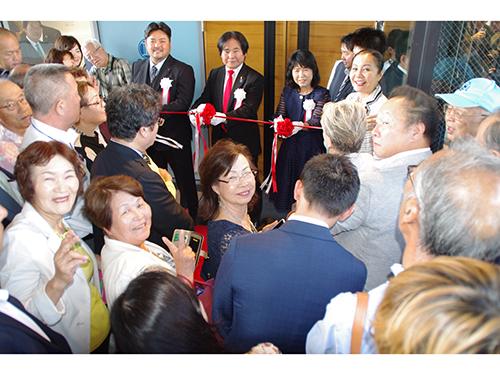 エントランスで行われたテープカット（中央が大城会長）